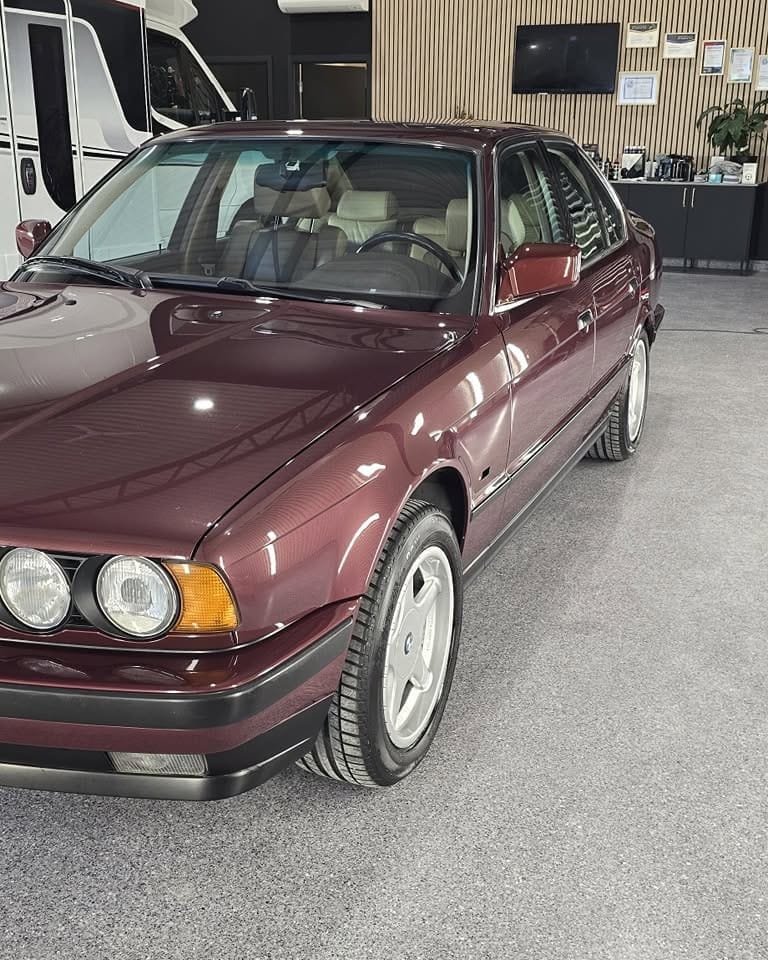 Burgunderrød BMW 535i fra 90-tallet med fornyet lakk i studioet