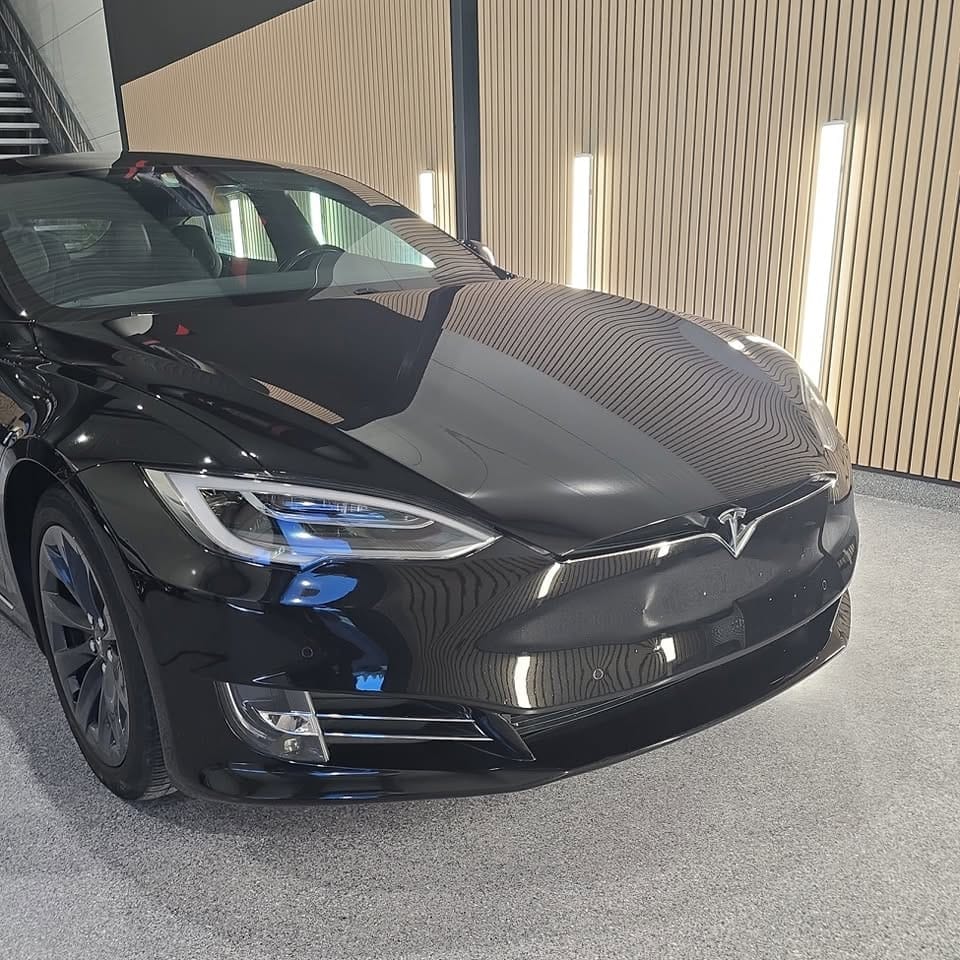 Svart Tesla Model S med blank front og panser i studioet