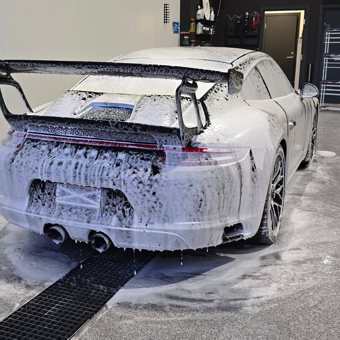 Porsche 911 GT3 dekket av hvitt vaskeskum i vaskehallen